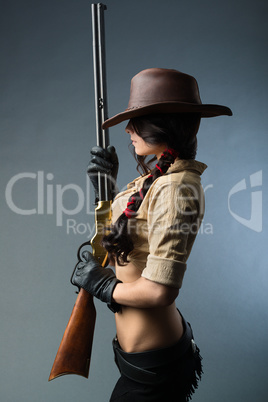 beautiful girl cowboy with  gun on a gray background