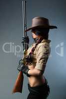 beautiful girl cowboy with  gun on a gray background
