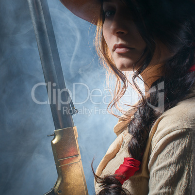 girl cowboy with  gun on a gray background
