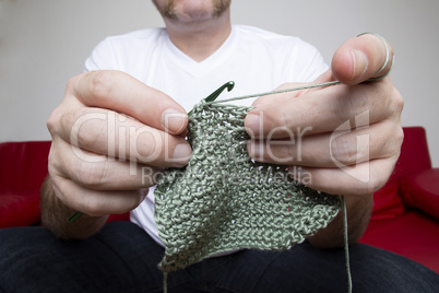 Closeup of a man knitting a scarf