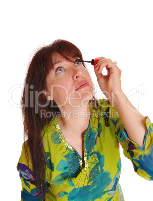 Woman putting makeup on her eyelashes.