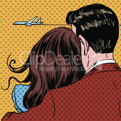 Loving couple looking at a plane taking off in the sky