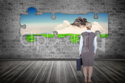 Composite image of back turned businesswoman holding a briefcase