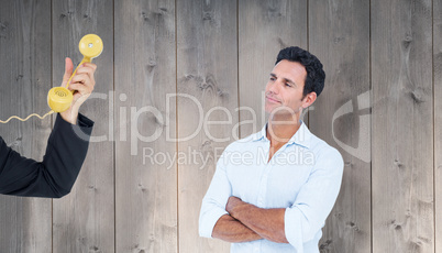 Composite image of handsome man standing with arms crossed