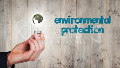 Composite image of hand holding environmental light bulb