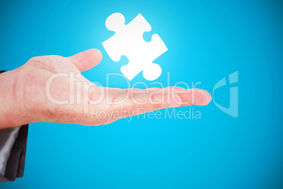 Composite image of businessman holding out his hand