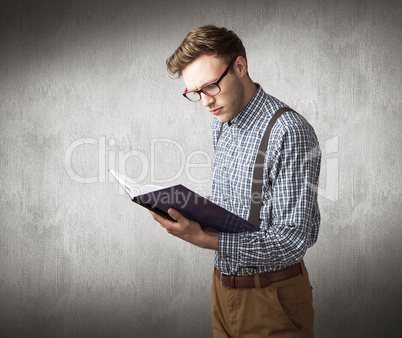 Composite image of geeky student reading a book