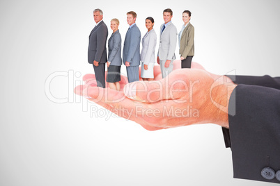 Composite image of business team standing in row and smiling at