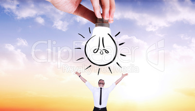 Composite image of hand holding light bulb doodle
