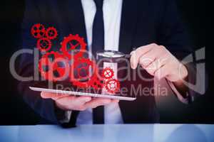Composite image of businessman looking at his tablet through mag