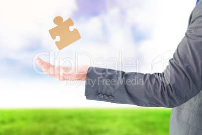 Composite image of businessman holding his hand out