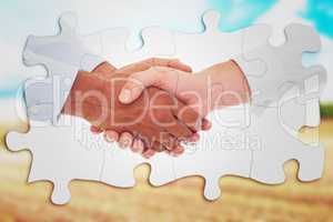 Composite image of close-up shot of a handshake in office