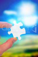 Composite image of hand holding jigsaw piece