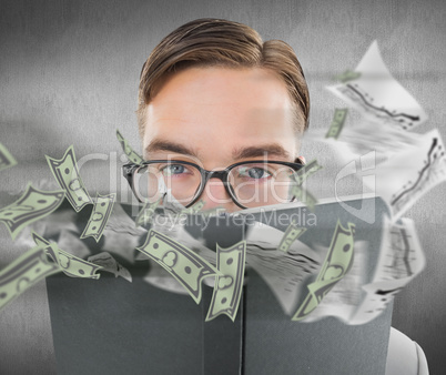 Composite image of geeky man looking over book