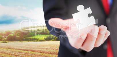 Composite image of businessman presenting with his hand