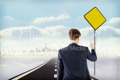 Composite image of businessman pointing something with his finge