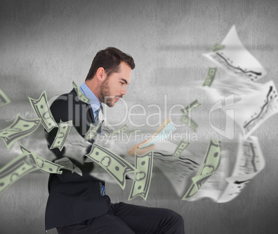 Composite image of businessman lying on the floor while reading