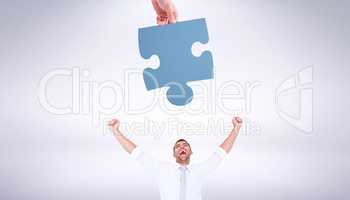 Composite image of hand holding jigsaw piece