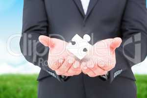 Composite image of businessman holding his hands out