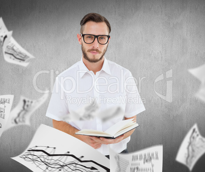 Composite image of geeky young man reading from black book