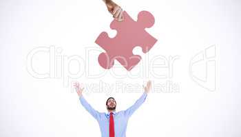 Composite image of hand holding jigsaw piece