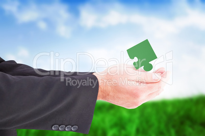 Composite image of businessman holding something with his hands