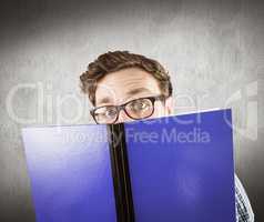 Composite image of geeky student reading a book