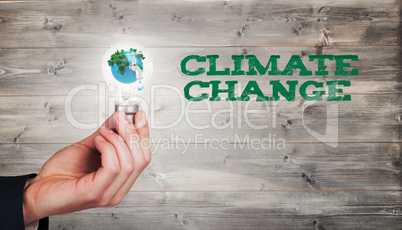 Composite image of hand holding environmental light bulb