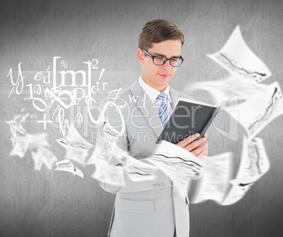 Composite image of geeky businessman reading black book