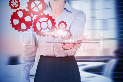 Composite image of businesswoman holding digital tablet