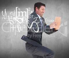 Composite image of businessman lying on the floor reading a book