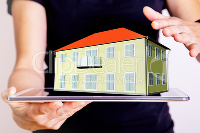 Hand holding Tablet PC with 3d house