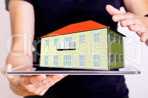 Hand holding Tablet PC with 3d house