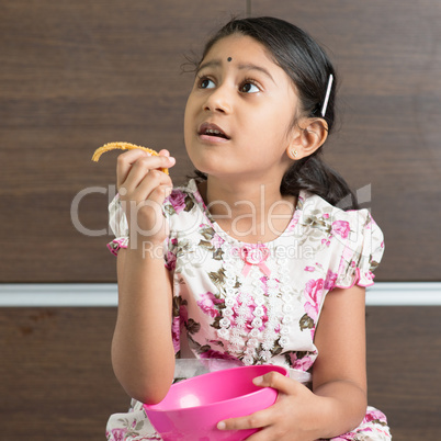 Indian girl eating cookie