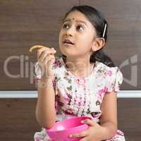 Indian girl eating cookie