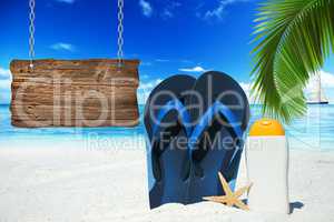 Flip Flops, Sonnenmilch und ein Holzschild am Strand