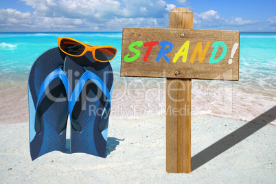 Flip Flops, Sonnenbrille und Holzschild mit Text STRAND