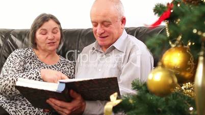 Senior couple going through photo album on Christmas