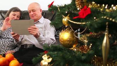 Seniors couple using tablet computer talking with video chat