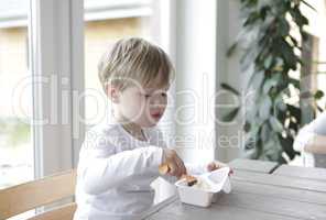 Junge ißt Jogurt