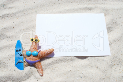 Leere Postkarte mit Seesternfigur im Sand