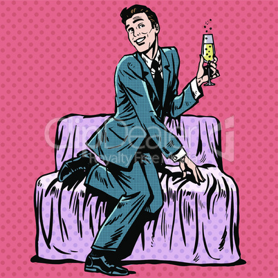 Playful man with a glass of champagne on the couch