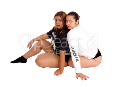 Two lovely young woman sitting on floor.