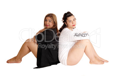 Two woman sitting back to back.