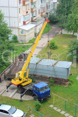 truck with hoisting crane loading the wagon