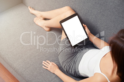 Woman takes a rest with tablet, on sofa