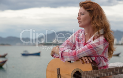 beautiful red-haired girl with a guitar