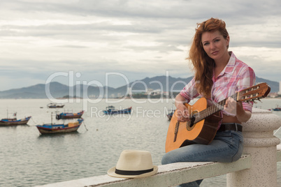 beautiful red-haired girl with a guitar