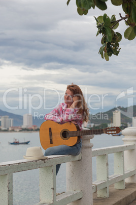beautiful red-haired girl with a guitar