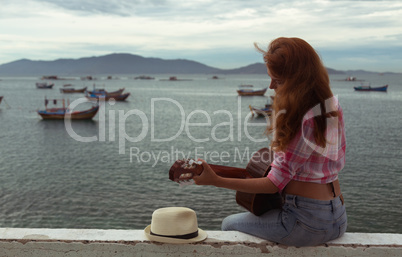 beautiful red-haired girl with a guitar